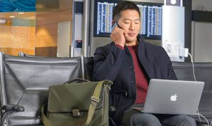 man-sitting-in-terminal-with-laptop-heroA-apac